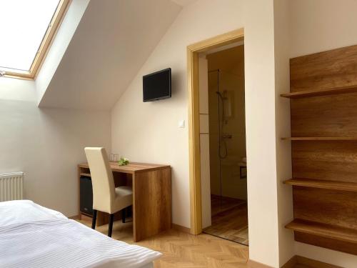BólyMagtár Villa的一间卧室配有一张床和一张书桌及电视