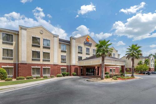 斯泰茨伯勒Comfort Inn & Suites Statesboro - University Area的街道前有棕榈树的酒店