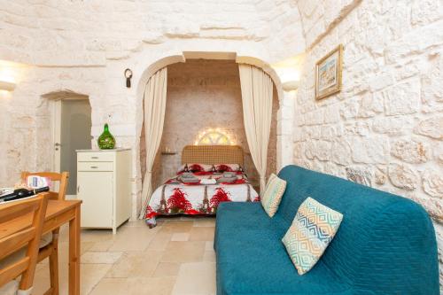 奥斯图尼Lovely Stone House In Ostuni的一间卧室配有一张床和一张蓝色的沙发