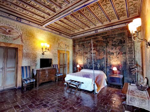 博尔塞纳1533年威斯康特住宿加早餐旅馆的一间卧室配有一张床,并在一间客房内配有电视。