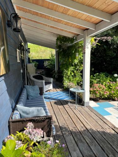 瓦尔德Bed en breakfast Onder aan de dijk的木制甲板上配有沙发的庭院