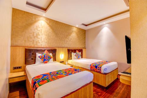 班加罗尔FabHotel S Comfort Inn的酒店客房设有两张床和电视。