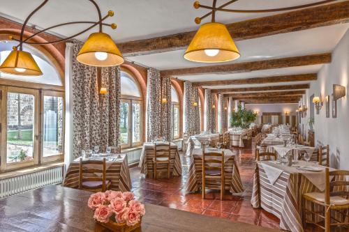 Yesa莱尔修道院酒店的餐厅设有桌椅和窗户。
