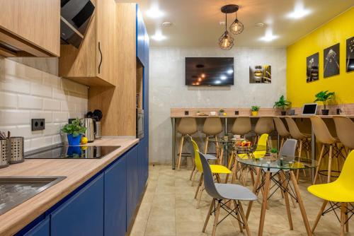 索契HiLoft Hostel的厨房以及带黄色椅子和桌子的用餐室
