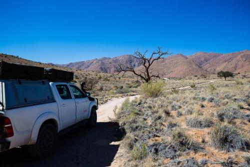 索利泰尔Camp Gecko - PRIVATE NATURE RESERVE; TENTED CAMP AND CAMPSITE的停在沙漠土路上的一辆白色卡车
