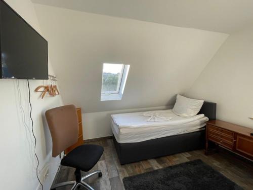 LangenbrandGrüner Baum的小房间设有一张床、一张桌子和一把椅子