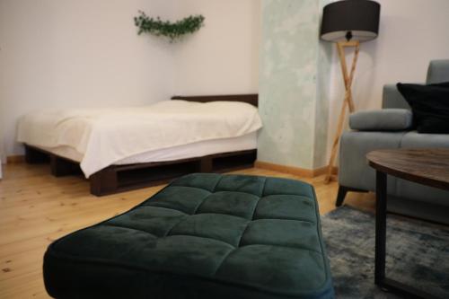 柏林Apartment Lodge 61的客厅配有一张床和一个绿色的搁脚凳