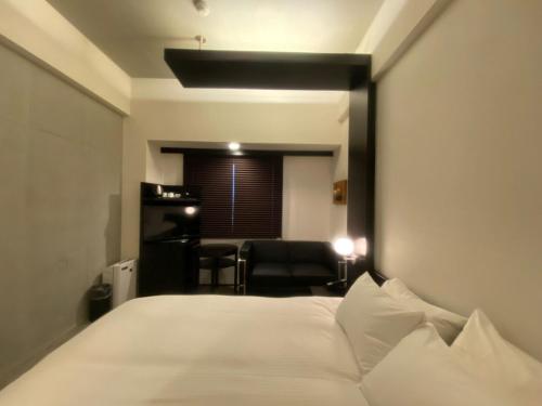 富良野ＦＵＲＡＮＯ ＮＡＴＵＬＵＸ ＨＯＴＥＬ - Vacation STAY 68187v的卧室配有一张白色大床和一把椅子