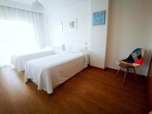 波尔蒂芒Terraços do Rio的白色卧室配有床和椅子