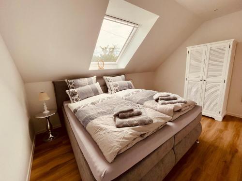 诺德代希Exklusive Ferienwohnungen MEERLIEBE Norddeich的一间卧室配有带毛巾的床