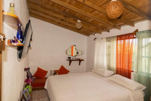 圣克里斯托瓦尔Ideal y linda casita en San Cristóbal-Galápagos的卧室配有白色的床和窗户。