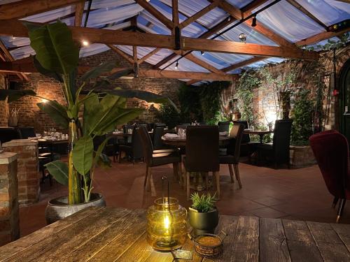 亨伯河畔巴顿Imaginarium restaurant的一间设有木桌和植物的餐厅