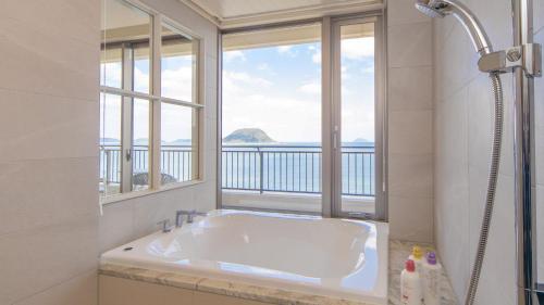 唐津唐津海滨酒店的白色的浴室设有浴缸和窗户。