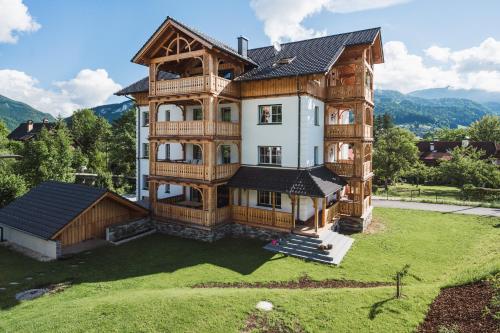 巴德哥依斯恩Ferienwohnungen Villa Salzweg的一座大型木屋,在庭院的顶部设有阳台