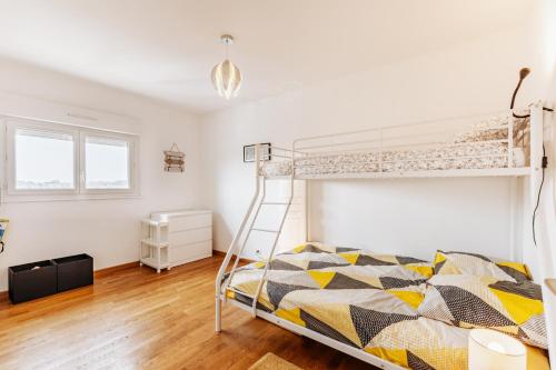 库尔瑟勒·苏尔·梅尔Gwenhen - Appartement vue mer的一间卧室配有一张双层床和梯子