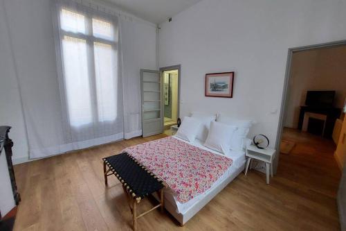 纳博讷Les clématites的白色的卧室设有床和窗户