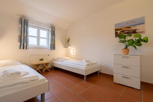 德兰斯克Feriendorf Rugana - Klassik Appartement mit 2 Schlafzimmern und Terrasse C27的一间卧室设有两张床和窗户。