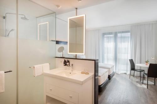美因河畔法兰克福INNSiDE by Meliá Frankfurt Ostend的一间带水槽的浴室和一张位于客房内的床