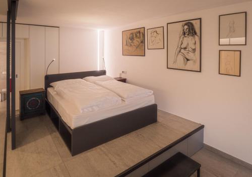 梅拉诺Sweet Piccolo Loft in centro con incantevole idromassaggio的墙上挂着照片的房间里一张床位