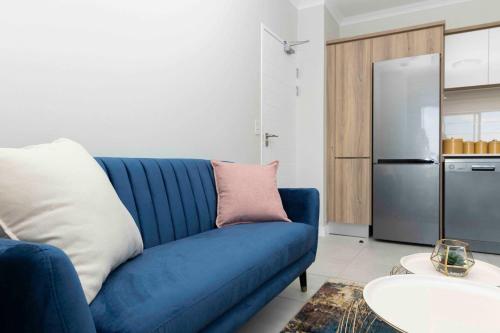 比勒陀利亚Blyde Haven B的客厅配有蓝色沙发,设有冰箱