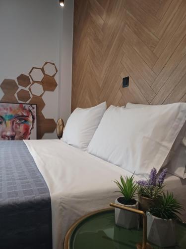 迈索隆吉翁Sroom Apartment的一间卧室配有一张床和一张盆栽桌子