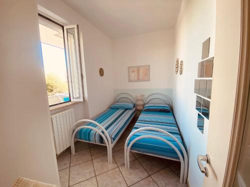 托雷坎内Brezza di Mare的带窗户的客房内设有两张单人床。