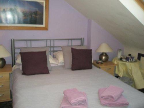 伦敦Kew Gardens National Archives Forest Road的一间卧室配有一张床,上面有两条粉红色的毛巾