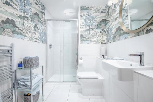 圣安德鲁斯Deluxe Penthouse Apartment w Roof Terrace的带淋浴、盥洗盆和卫生间的浴室