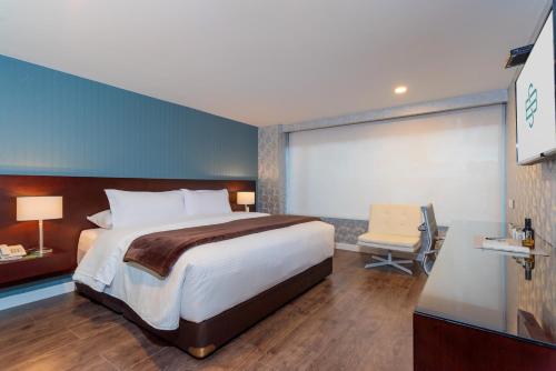 波哥大圣巴巴拉精品酒店的酒店客房带一张大床和一把椅子