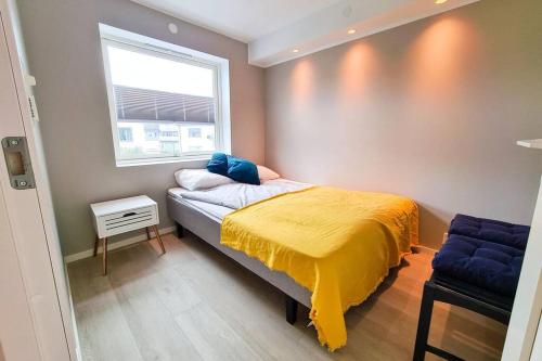 波多Aurora Central Apartment, Bodø的一间卧室配有一张黄色毯子床