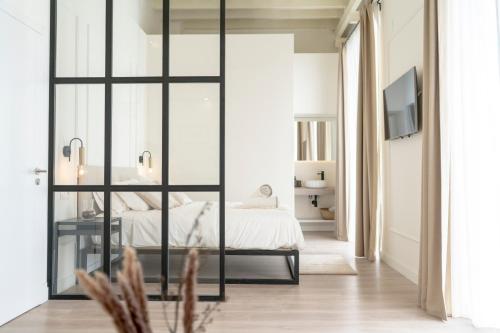 赫雷斯-德拉弗龙特拉Suites Alfonso X的一间卧室设有一张床和一个滑动玻璃门