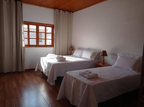 蒂拉登特斯Residencia Sao Miguel的一间卧室设有两张床和窗户。