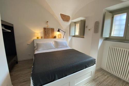贝加莫Casa Meraki - Apartment的卧室配有床,位于带2个窗户的房间