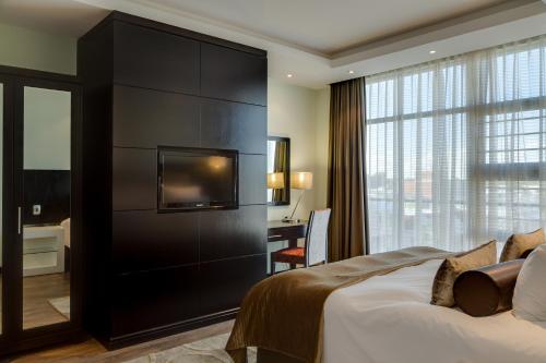 乌平通The Oasis的酒店客房配有一张床、一张书桌和一台电视。