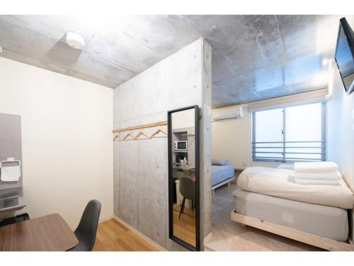 东京bmj Hyakunincho - Vacation STAY 68273v的一间卧室配有一张床、一张书桌和一面镜子