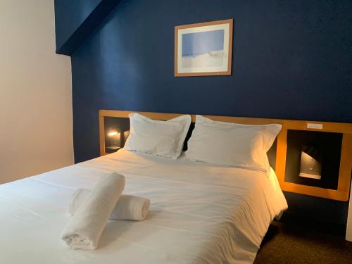 波城Hôtel Montilleul - Villa Primrose的一张配有白色床单和枕头的大床