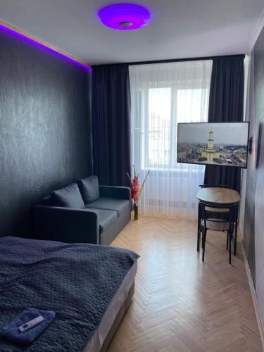 伊万诺-弗兰科夫斯克Ehostel360的一间卧室配有一张床、一张沙发和一台电视。