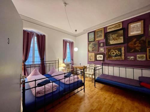 海德堡海德堡杰斯克旅馆的墙上挂有绘画的客房内的两张床