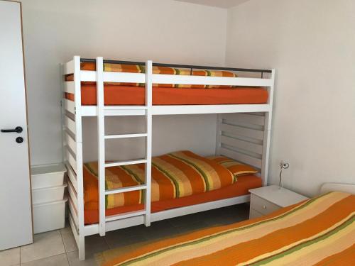 博斯克古林Appartamento da 2 locali a Bosco Gurin的一间卧室配有两张双层床和橙色床