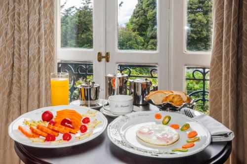 波哥大波哥大勒马努瓦尔酒店的一张桌子,上面放着两盘食物和橙汁