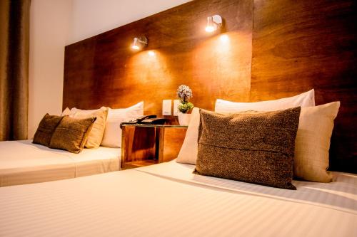 图斯特拉古铁雷斯Hotel del Carmen, en el Centro- DESAYUNO Incluido !的酒店客房设有两张床和木制床头板。