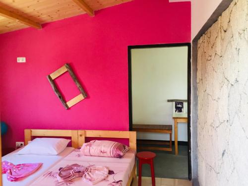 波多诺伏Pedra de Rala的卧室设有粉红色的墙壁、一张床和镜子
