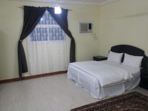 哈伊勒العييري للشقق المفروشة حائل1的卧室配有白色的床和窗户。