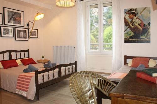 拉马莱恩Hôtel des Bateliers的一间卧室设有两张床、一张桌子和一个窗口