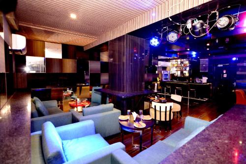 斋浦尔斋浦尔主题旅馆的一间带蓝色沙发的客厅和一间酒吧