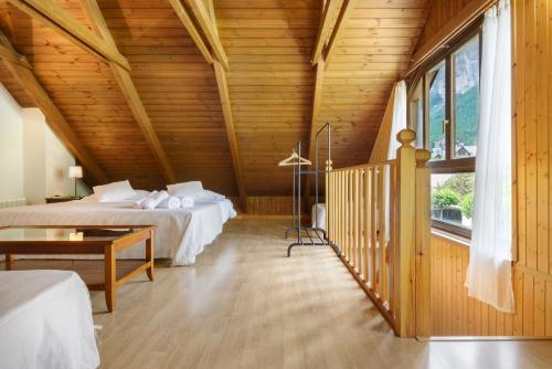 伊斯卡日拉Alojamiento Escarrilla Pirineos的一间卧室设有两张床和木制天花板