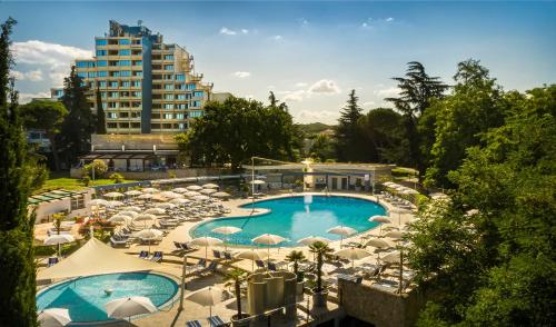 波雷奇Valamar Diamant Hotel的享有带遮阳伞的游泳池和大楼的景致。