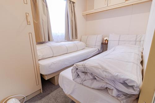 乌伊格Skye Holiday Chalets C1的小型客房 - 带2张床和窗户