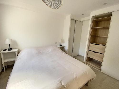 昂蒂布Superbe appartement au cœur du Cap d'Antibes的卧室配有白色的床和衣柜。
