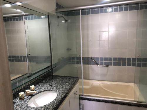 福塔莱萨Iate Plaza Beiramar Fortaleza app1006的浴室配有水槽、淋浴和浴缸。